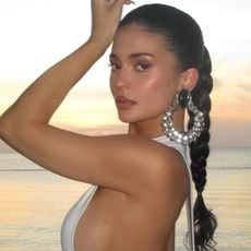 Kylie Jenner wore a little white Jacquemus dress with deep side cut-outs on vacation