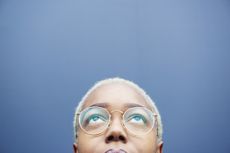 Close up of woman looking up on a blue background