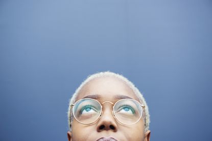Close up of woman looking up on a blue background