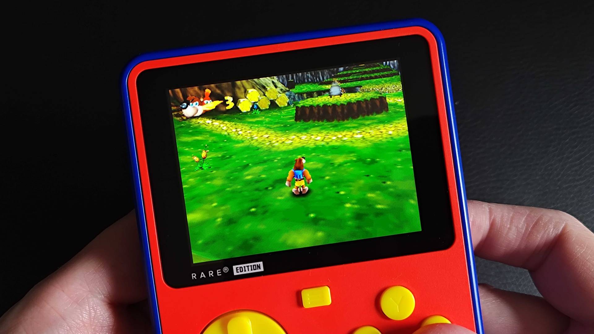 Close up of Super Pocket Rare Edition with Banjo-Kazooie gameplay on screen featuring Mumbo's Mountain.