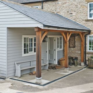 Cobbled house with cladded side porch and driveway