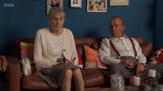 Gloria and Eddie Knight sitting on the sofa talking to George Knight.