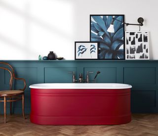 bathroom with white walls, blue painted panels with red painted tub, artwork, herringbone floor