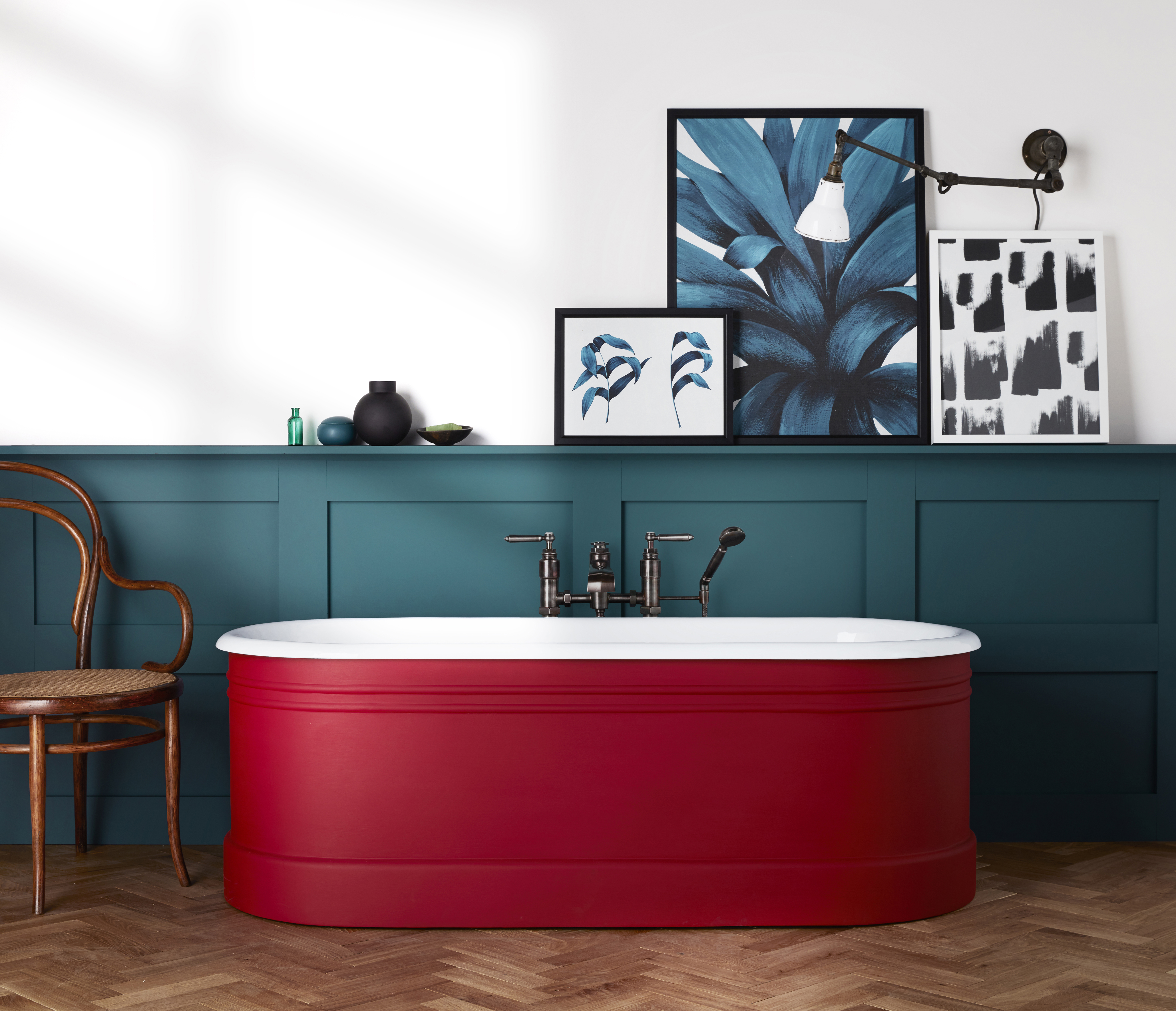 salle de bains avec murs blancs, panneaux peints en bleu avec baignoire peinte en rouge, œuvres d'art, sol à chevrons