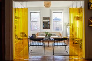 A New York living room apartment with plastic yellow curtains as dividers