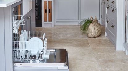 blue kitchen with stone tile floors and dishwasher