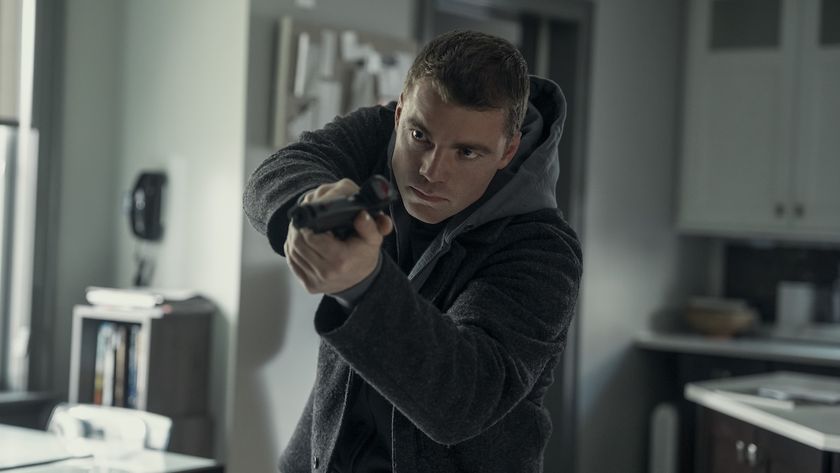 Gabriel Basso pointing his gun forward as he walks through a house in The Night Agent Season 3