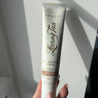 Hand holding Loving Tan Purest Face Tanning Serum