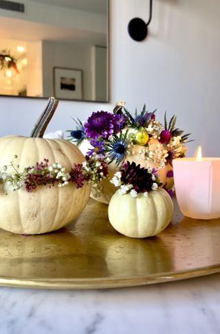 Decorative pumpkins on a table with a candle lit