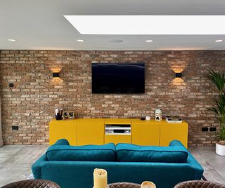 living room with brick wall and yellow unit