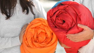 Couple carrying sleeping bags