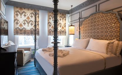 Bedroom of Hagia Sophia Mansions in Istanbul with large bed with upholstered headboard, window blinds and white bedding