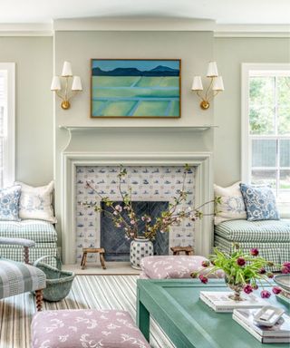 blue and white eclectic living room with a fireplace tiled with delft tiles and plaid window seats