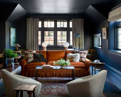 a dark living room with a tan sofa