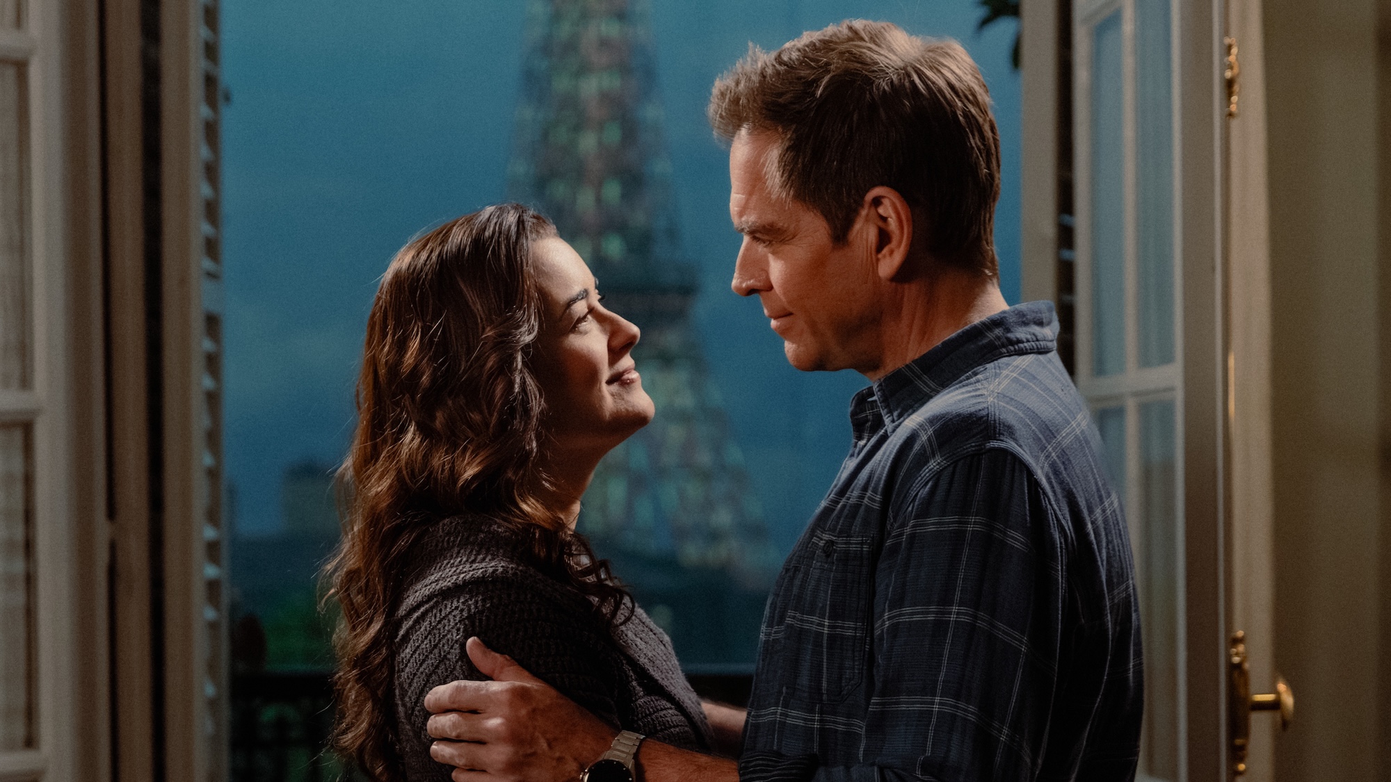 Tony and Ziva embracing and looking into each other's eyes in front of a window in NCIS: Tony &amp;amp; Ziva Season 1
