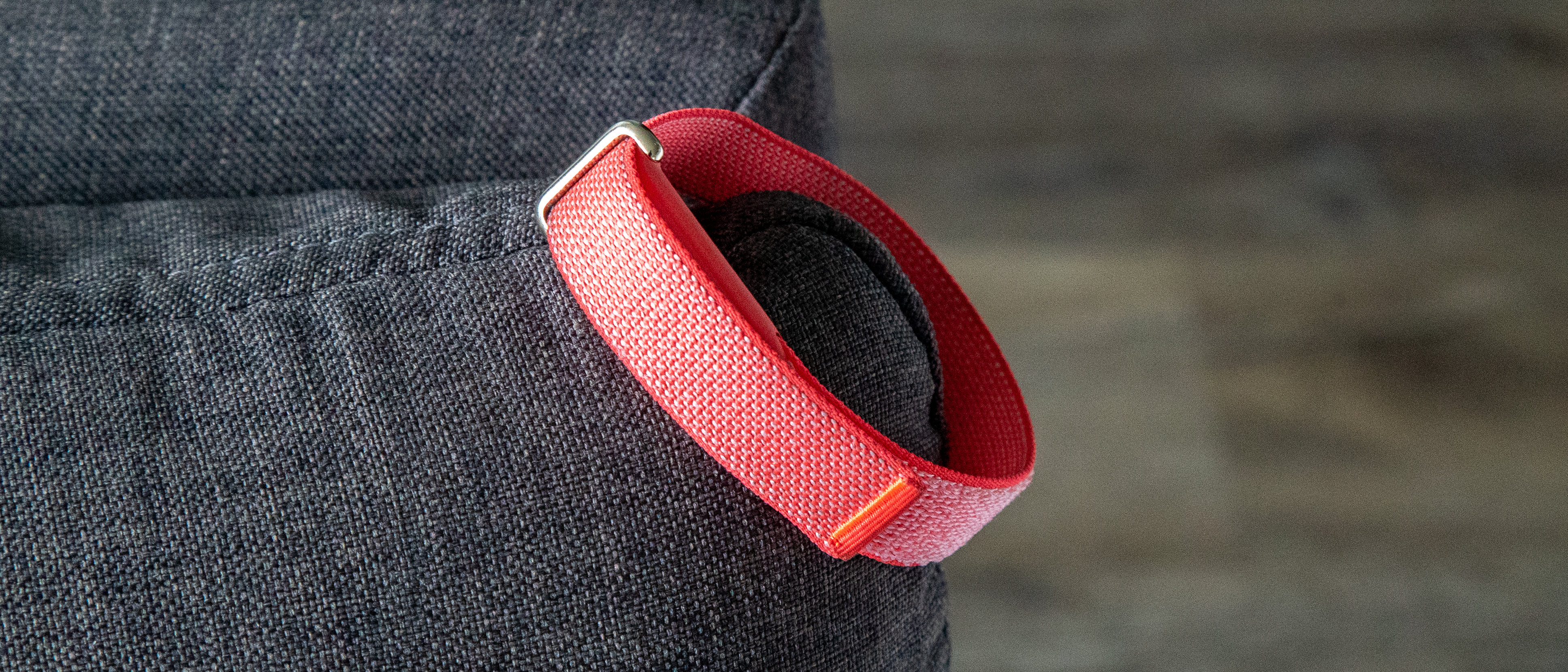 The Fitbit Air on the corner of a couch