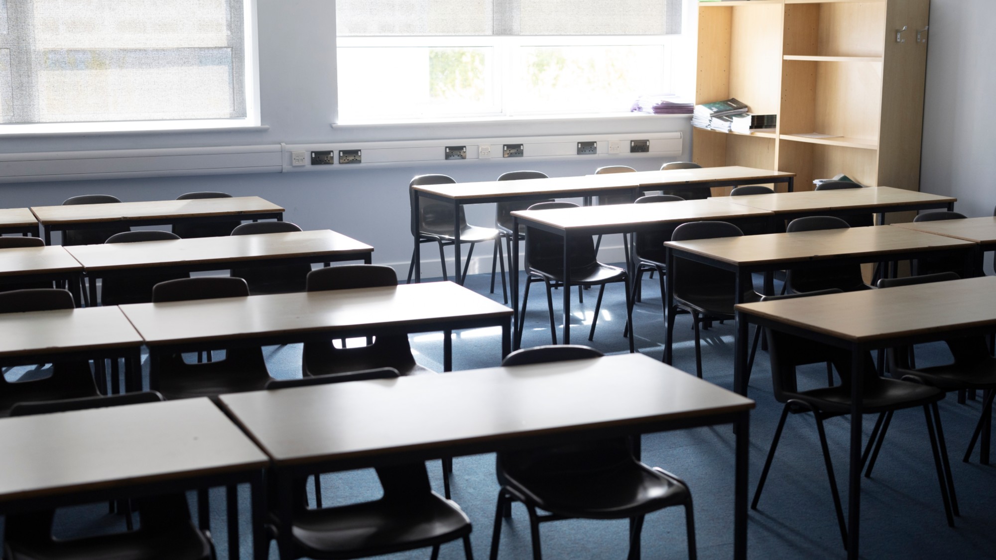 Row of empty desks and chairs at a school