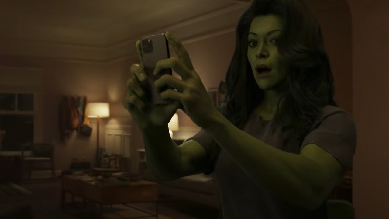 Tatiana Maslany's She-Hulk looks surprised as she checks her cellphone on the Disney Plus character show