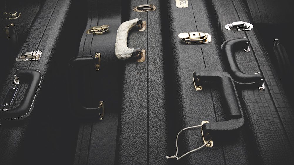 Electric and acoustic guitar hard cases lined up next to each other