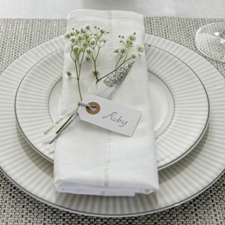 White place setting with name tag attached to napkin