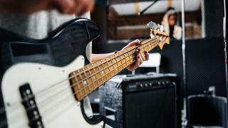 Close-up shot of a musicians hand playing a guitar in a record studio