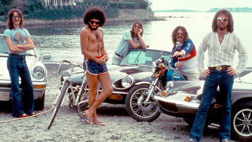 Boston posing at the beach with some sports cars