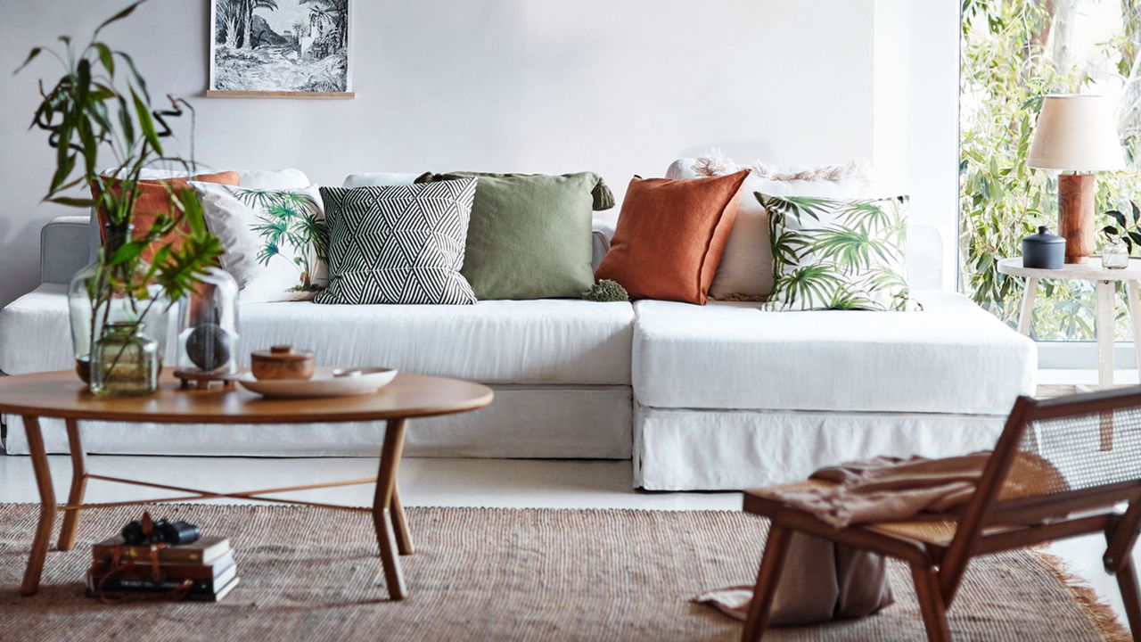 H&amp;M Home: Living room with tropical print cushions and a white sofa by H&amp;M Home