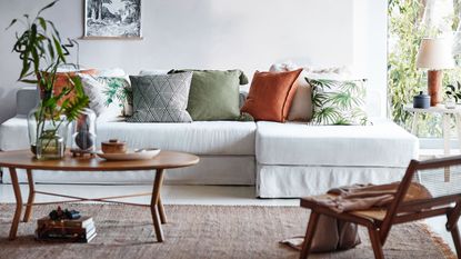 H&M Home: Living room with tropical print cushions and a white sofa 