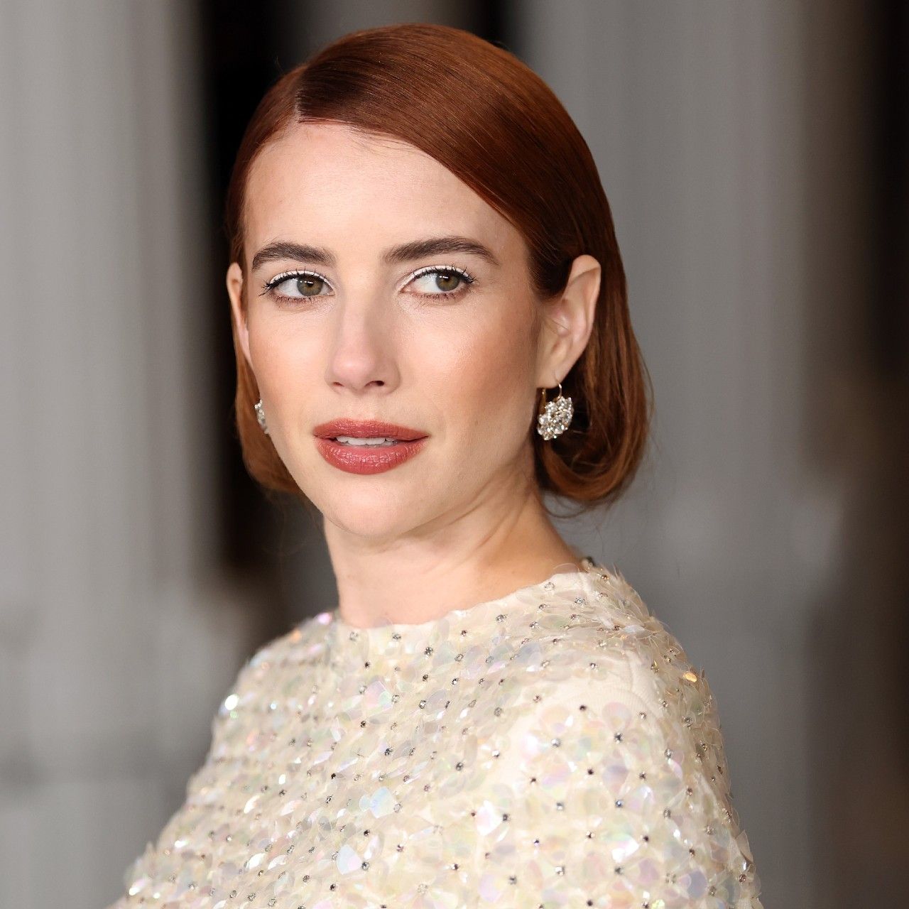 a white woman with red hair poses for a red carpet photo
