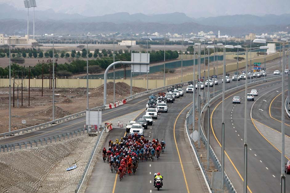 A long convoy of vehicles behind the peloton