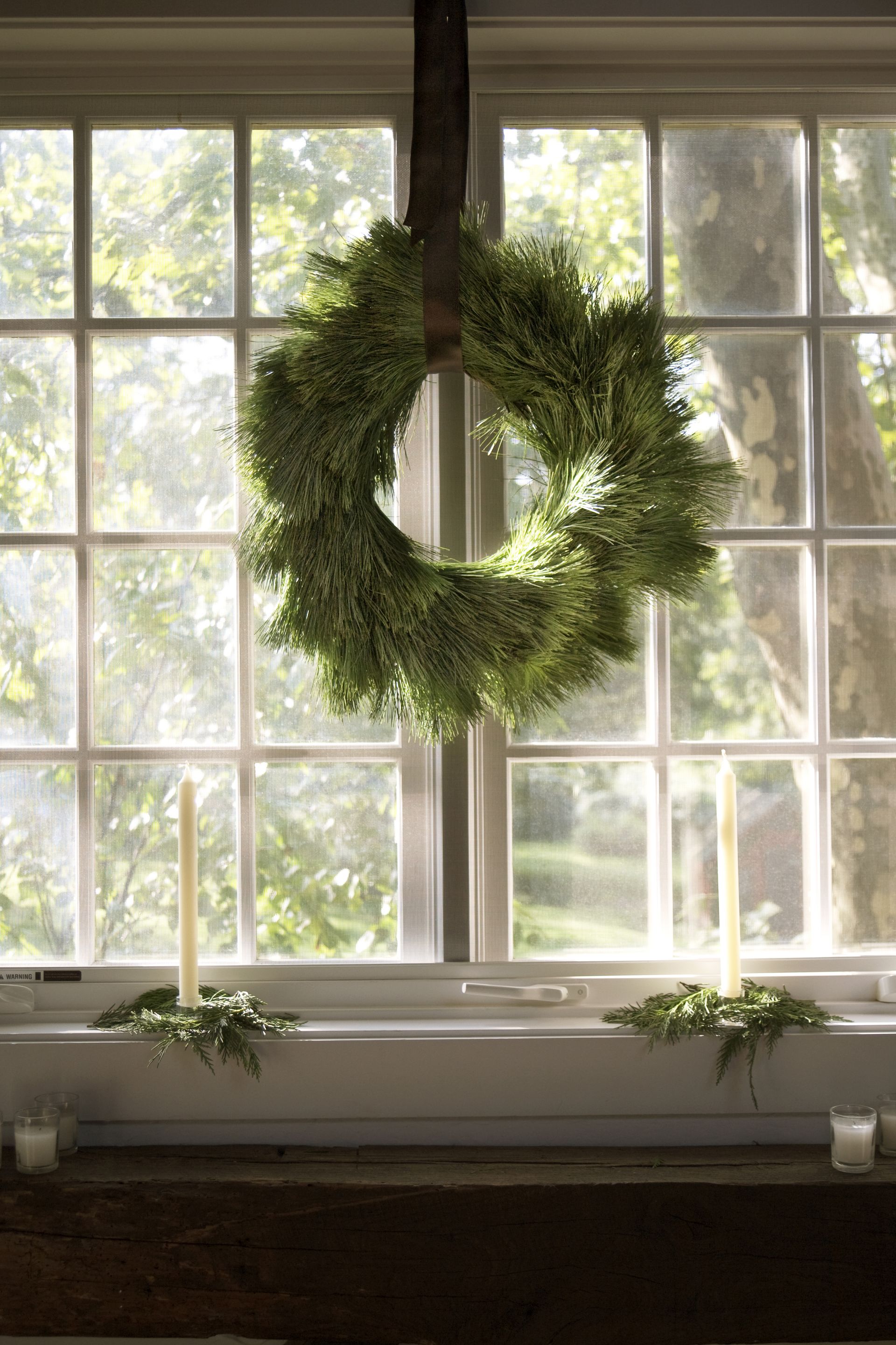 Χριστουγεννιάτικο στεφάνι που κρέμεται σε ένα παράθυρο