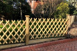 lattice wooden fence on driveway
