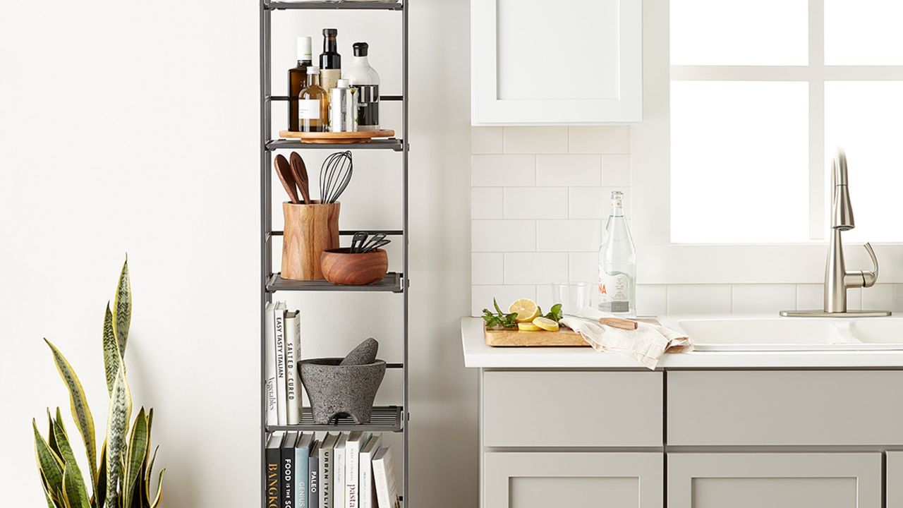 Folding tower storage in white bedroom with houseplant on side