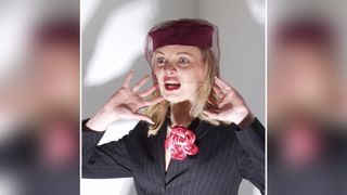 Color portrait of shocked person wearing vintage clothing, with harsh lighting directed from below head height