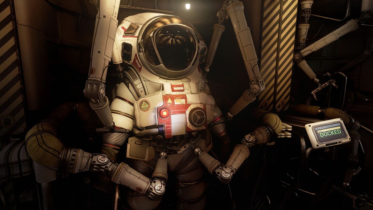 Looking at a bulky, white spacesuit in Ontos, which is tucked away by mechanical arms while a screen displays 'docked'