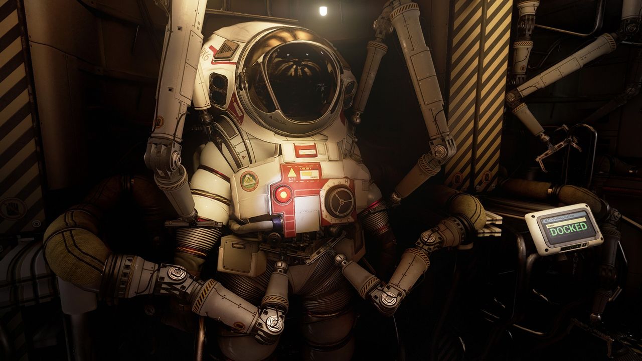 Looking at a bulky, white spacesuit in Ontos, which is tucked away by mechanical arms while a screen displays 'docked'