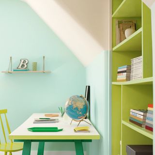 A kids' desk with a bookcase painted in bright green