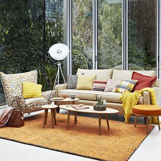 retro living area with sofa and cushions and arm chair