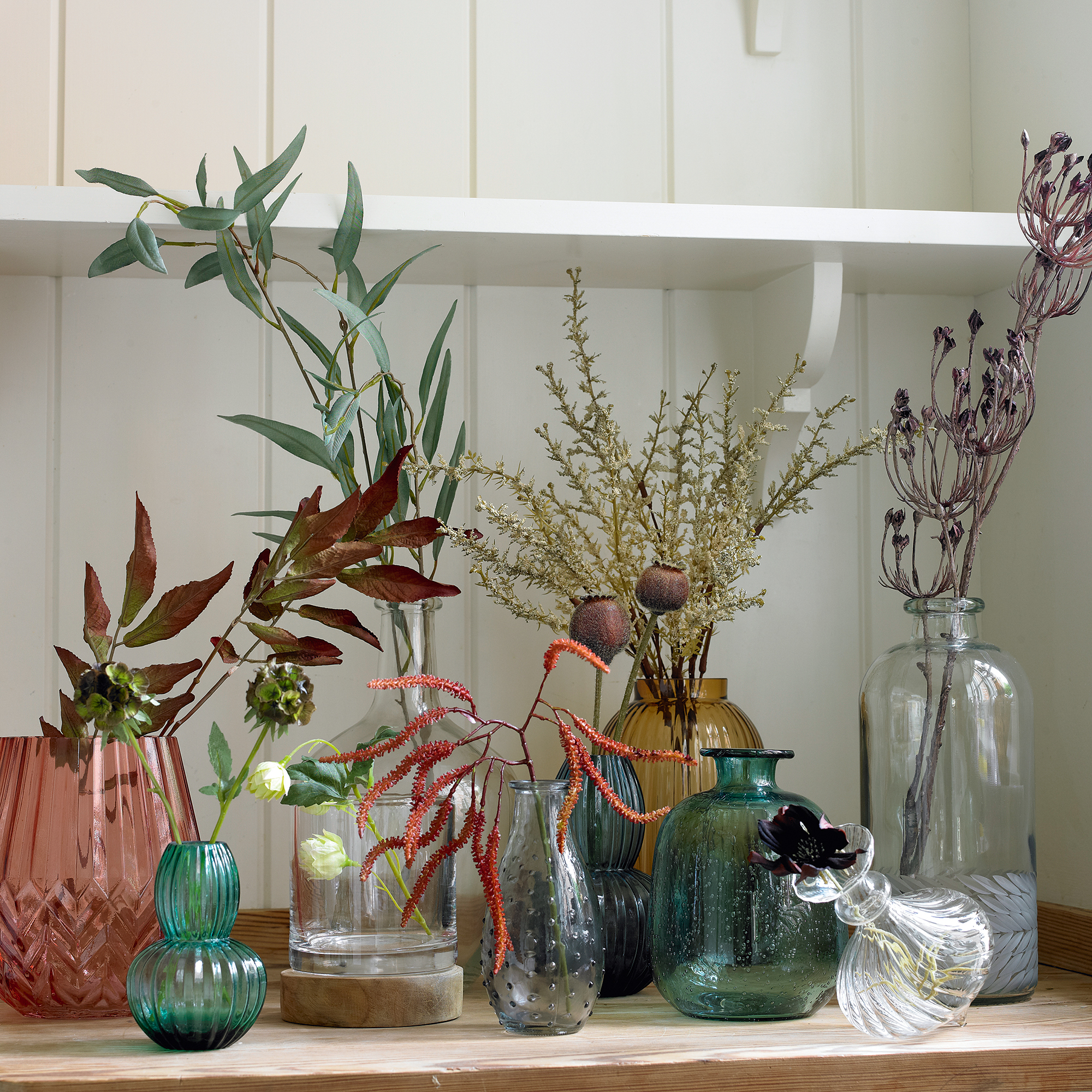 Collection of glass vases filled with foliage