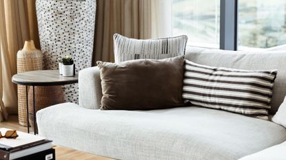 A white couch with cushions piled 