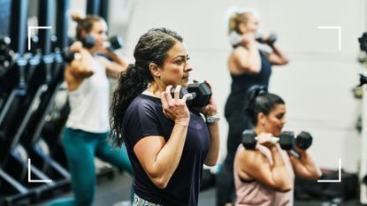 Woman holding a dumbbell under her chin in a gym class after learning how to lower metabolic age through strength training