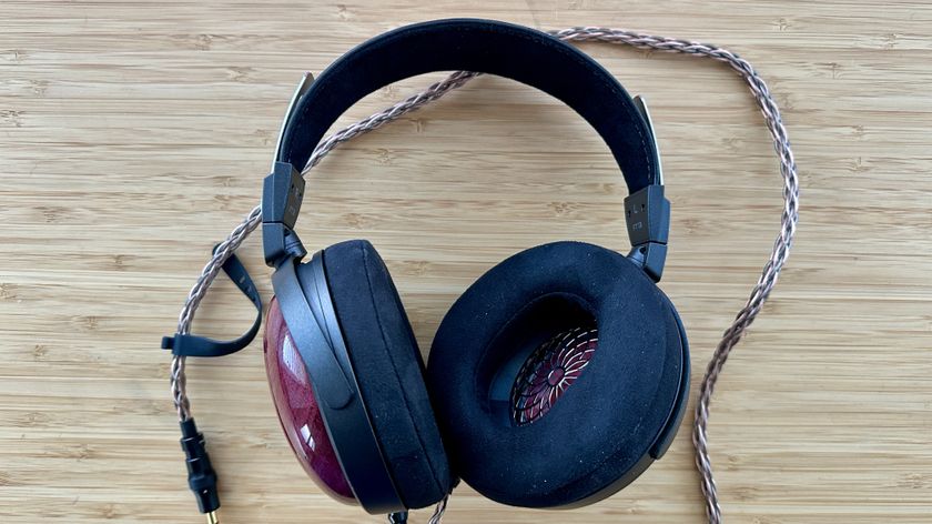 FiiO FT13 closed-back over-ear wired headphones, with braided wire, on a wooden surface.