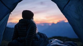 a camper looking out at a sunset in winter