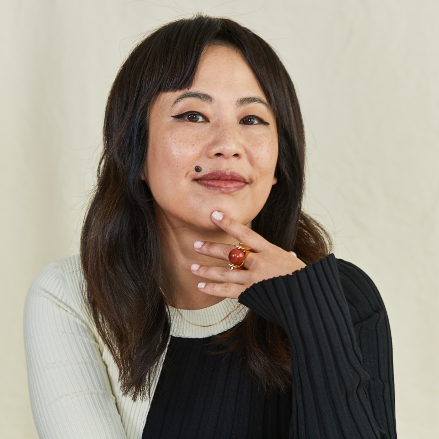 an asian woman with dark hair in a black and white sweater