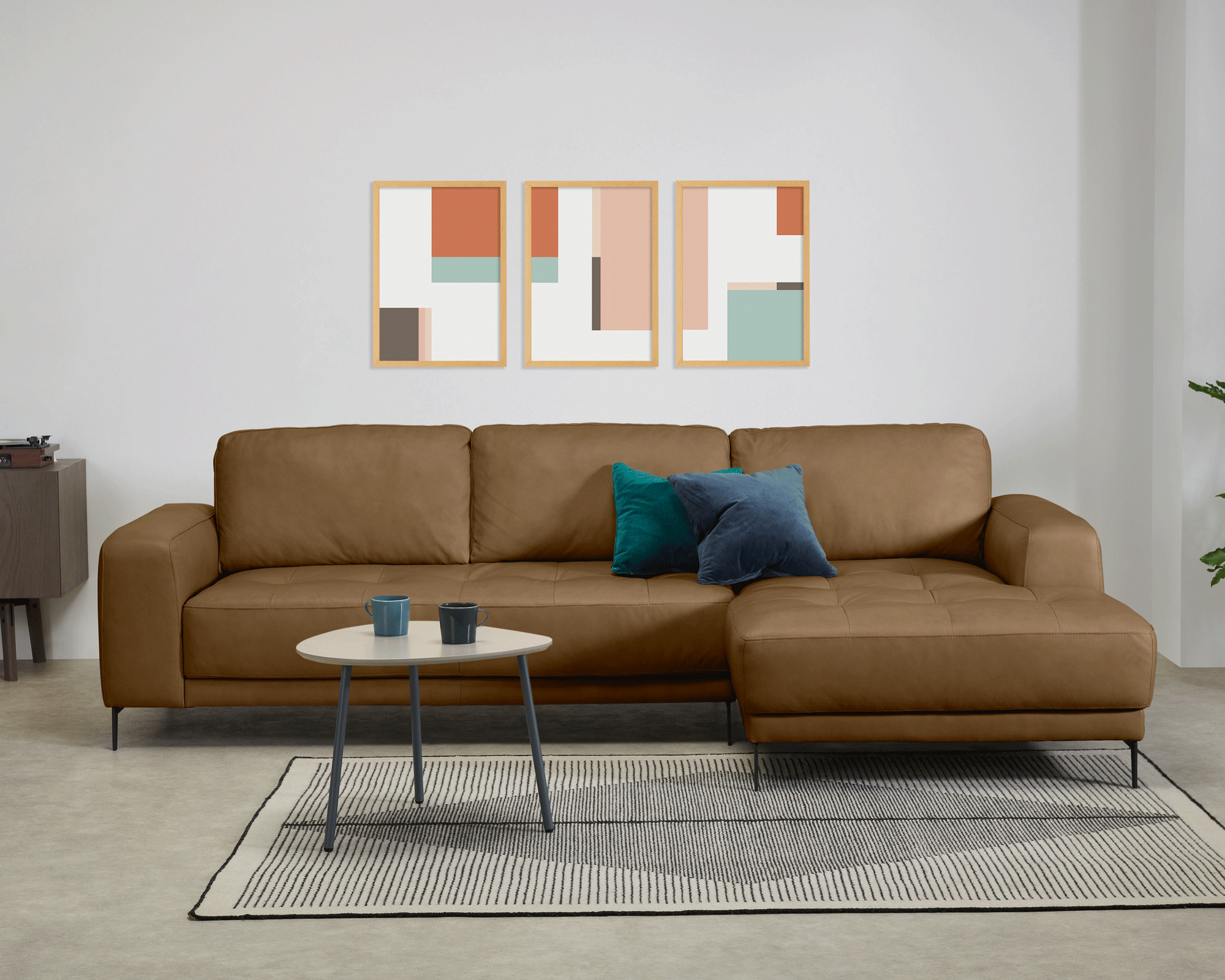 Made.com tan leather sofa, rug and coffee table with prints on wall