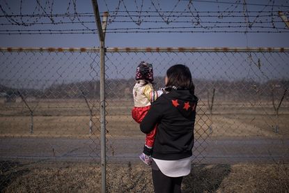 A mother and daughter look at North Korea from South Korea.