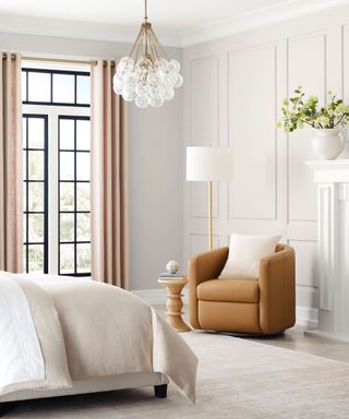 A neutral toned bedroom with a brown armchair in the corner and floor-to-ceiling windows