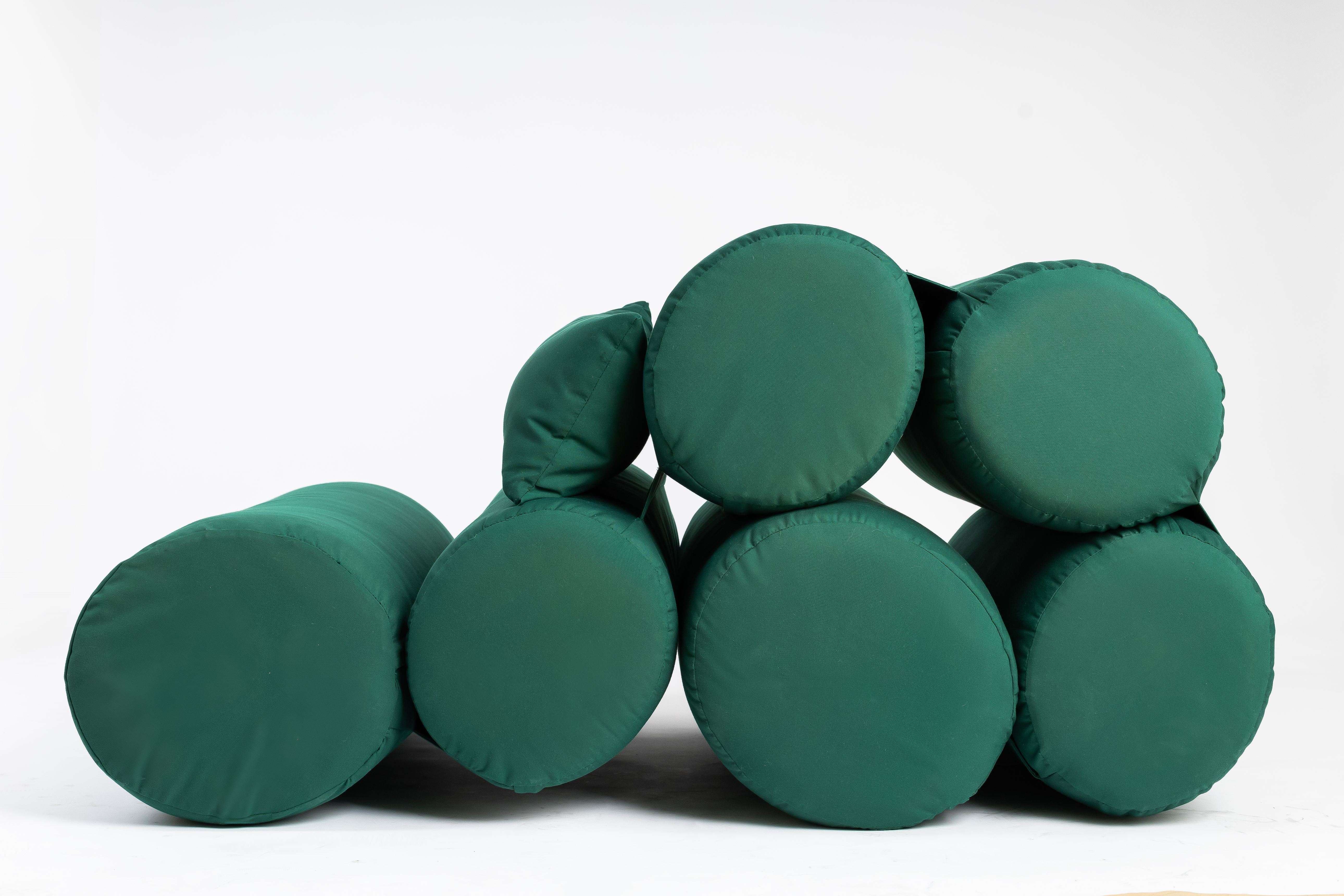 Green chaise longue made of sausage-like elements, seen from the side
