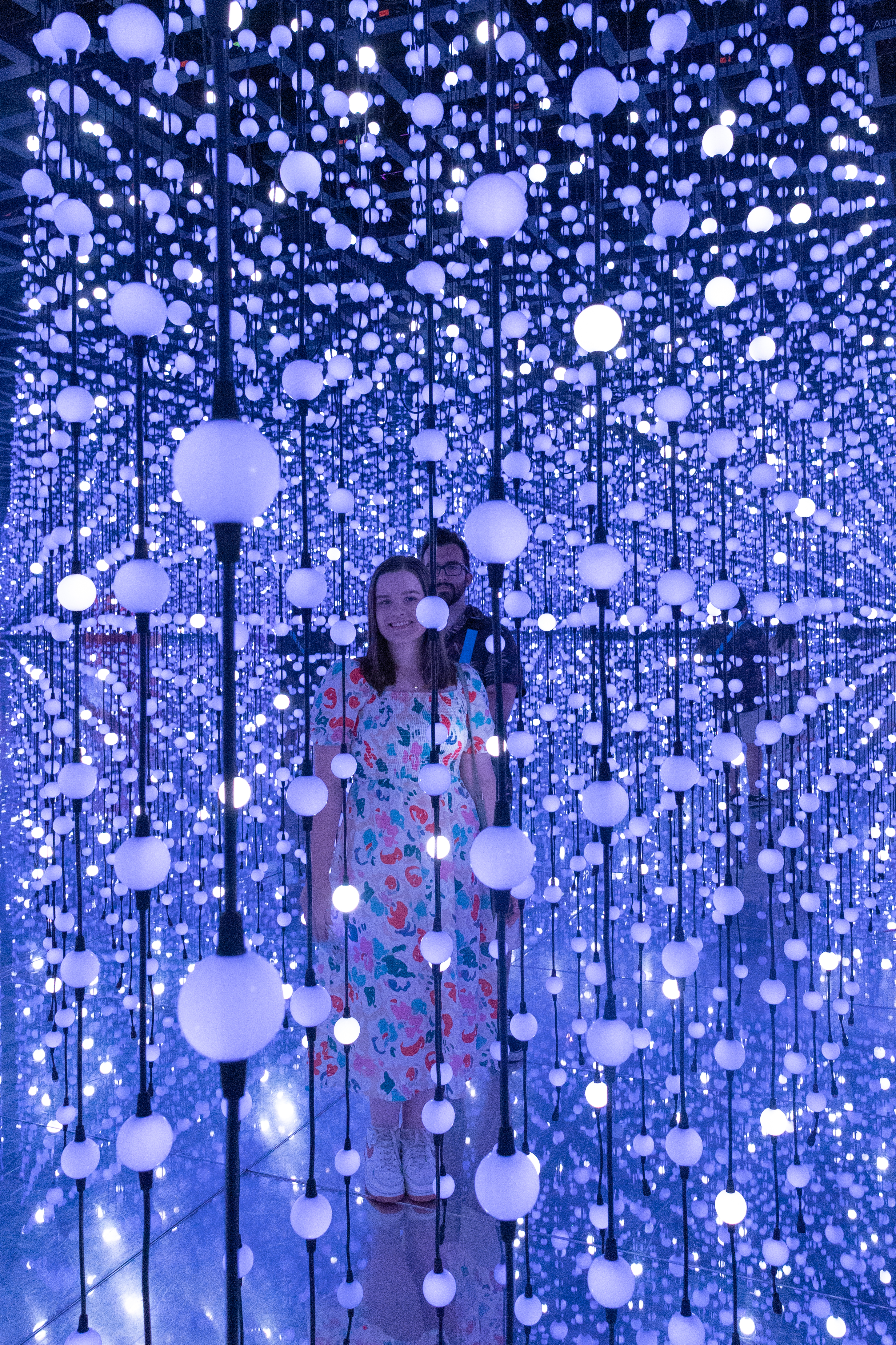 A photo of two people standing amongst multiple light balls taken on a Canon EOS R50 V mirrorless video camera