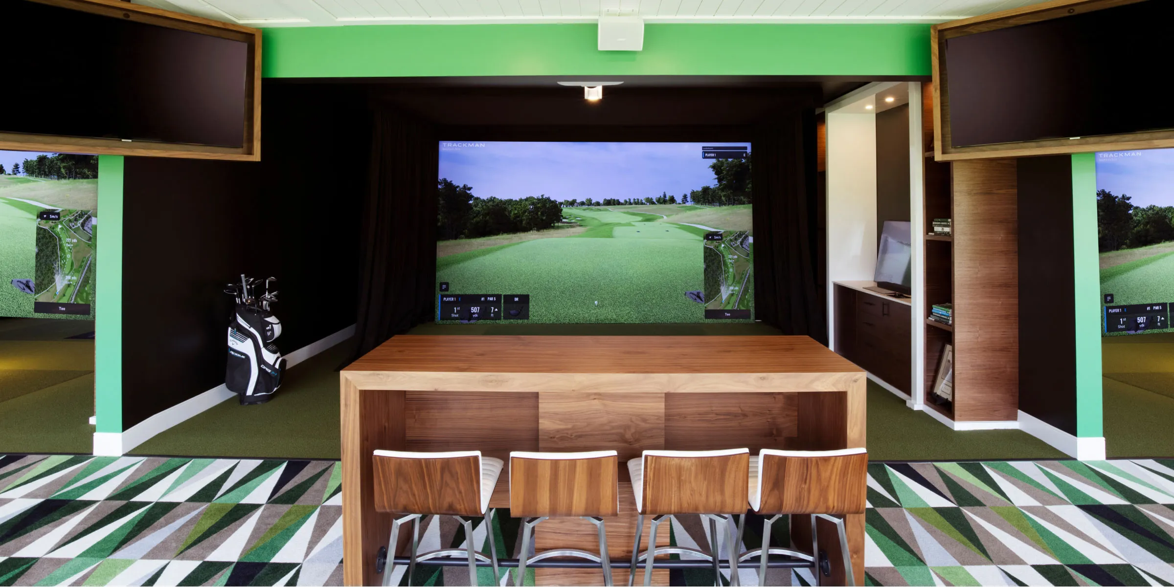 A golf &quot;classroom&quot; at Nemacolin Golf Academy, showing a desk with four chairs facing a simulator. From: https://www.nemacolin.com/golf/golf-academy/